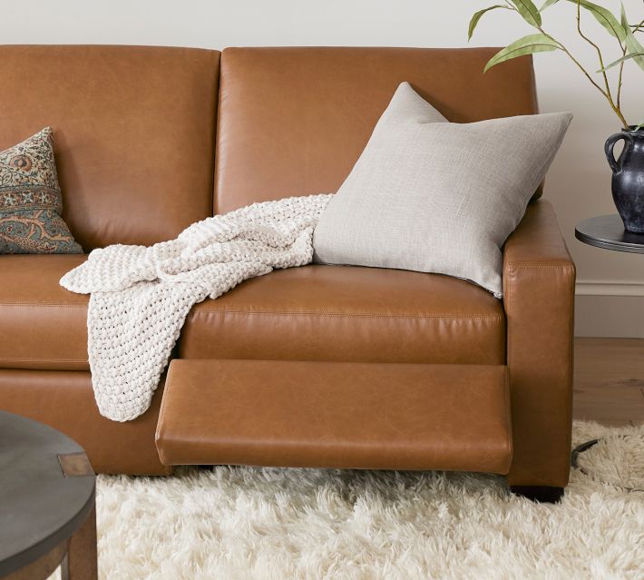 Close-up of knit blanket on leather sofa