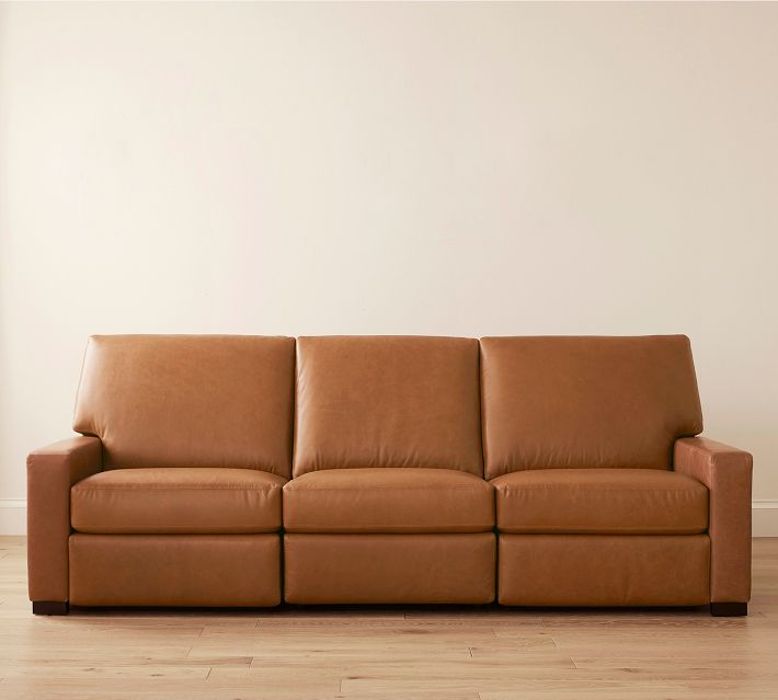 Three-seat brown leather sofa with clean lines against a light wall