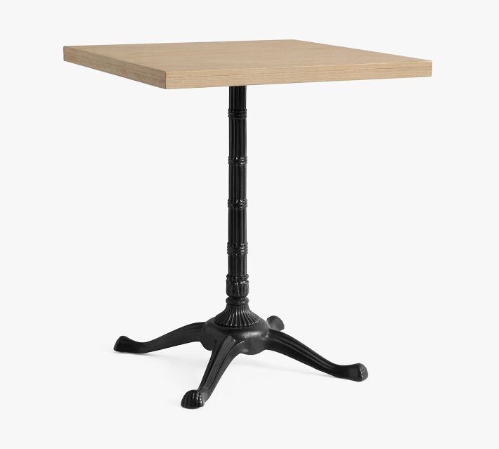 Close-up view of a light wood square tabletop with a black turned pedestal base