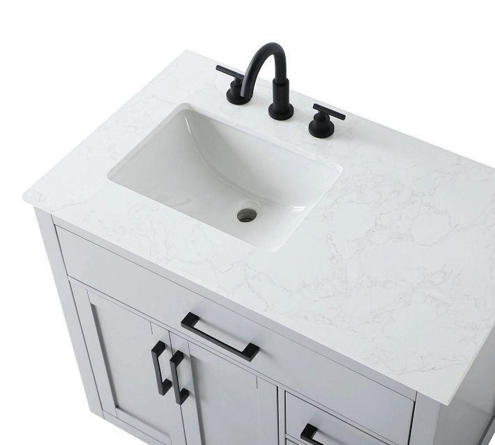 Top view of a white marble countertop with an integrated under-mount sink and black faucet fixtures.