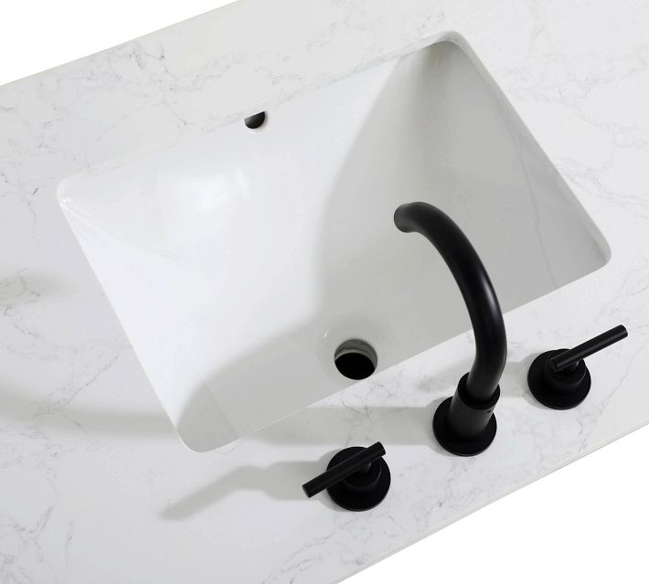 White rectangular bathroom sink with black faucet and handles mounted on marble-like countertop.