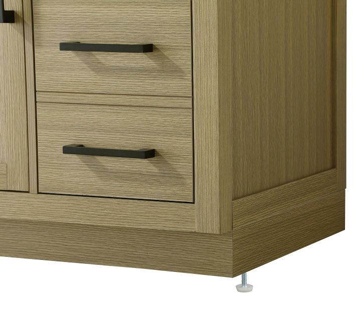 Close-up of wood grain and drawer handles on a light oak vanity.