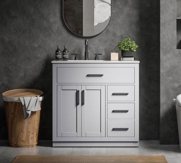 Close-up of grey bathroom vanity with a single large drawer and round knobs, showing assembly detail.