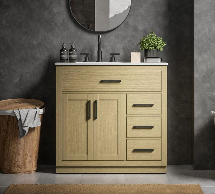 Natural wood-toned bathroom vanity with countertop sinks and dark hardware, set against dark walls.