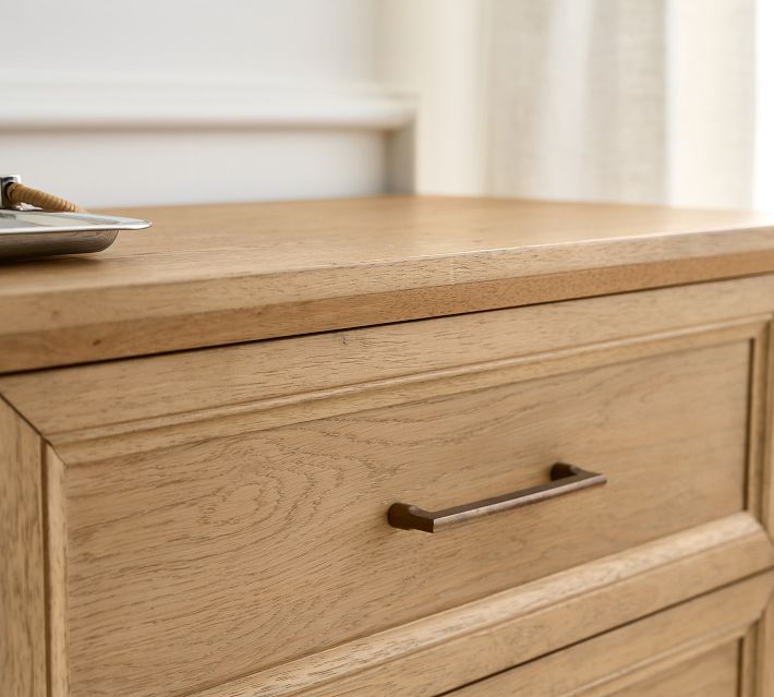 Close-up of dresser top with a plate and tray item, focusing on edge and finish.