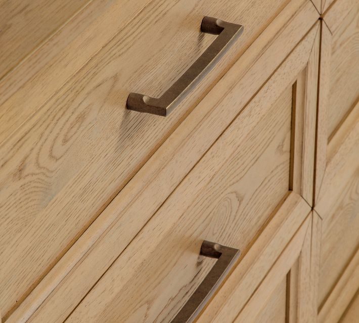 Close-up of a dresser handle and wood grain.