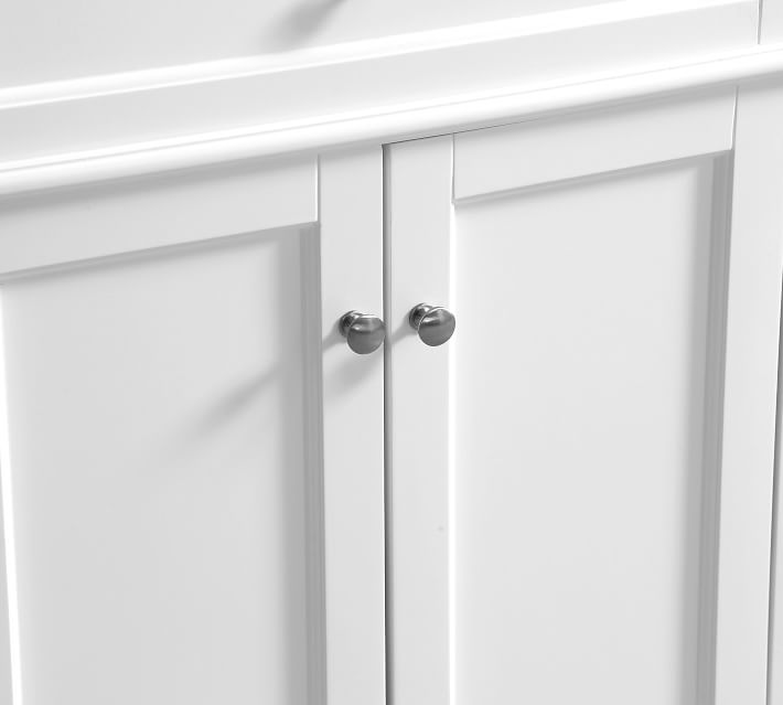 Front view of white bathroom vanity drawers and cabinet doors with chrome knobs.