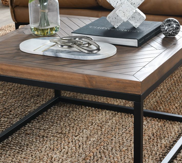 Close-up of coffee table top showing wood veneer and metal frame with decor on top