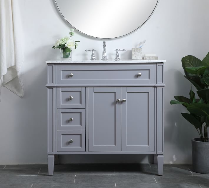 Grey painted vanity with marble top and mirrored round above, featuring multiple drawers and cabinet doors
