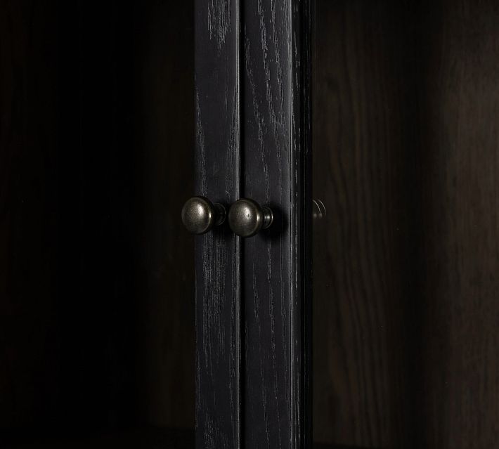 Close-up of cabinet door knob and wood grain.