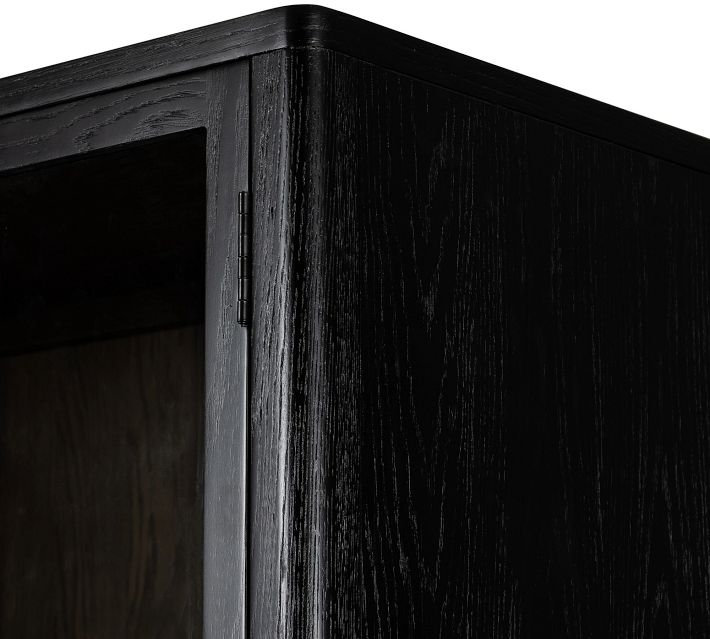 Top corner of cabinet with black finish and visible wood grain.
