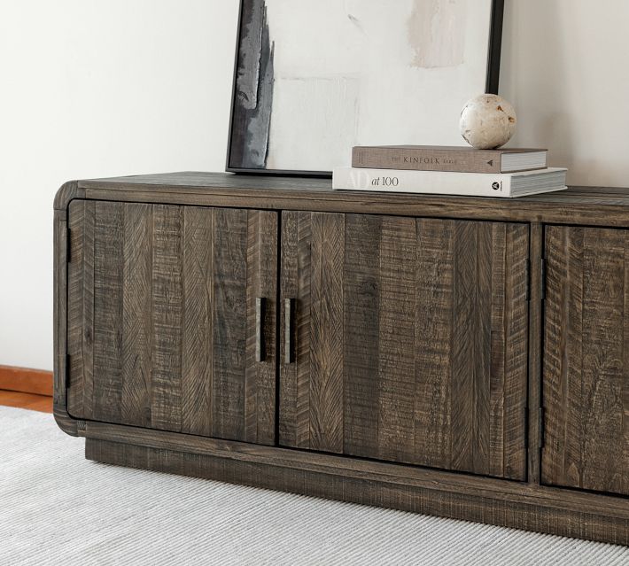 Close-up of the sideboard showing the right section with cabinet doors and stacked books on top, including a marble sphere.
