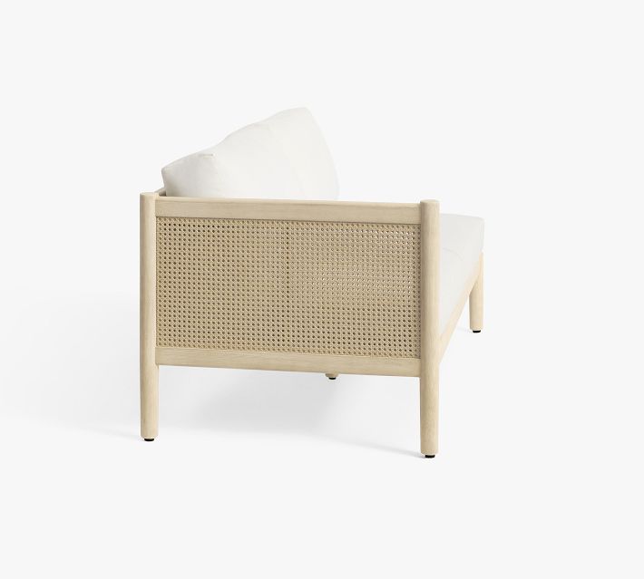 Side view of a single-cushion lounge chair with cane panel back