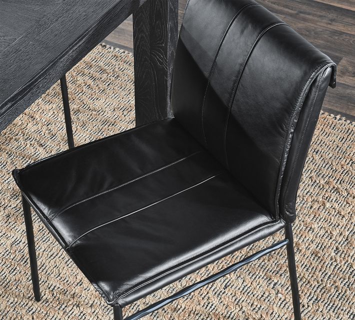 Close-up of black leather chair seat and back with metal legs