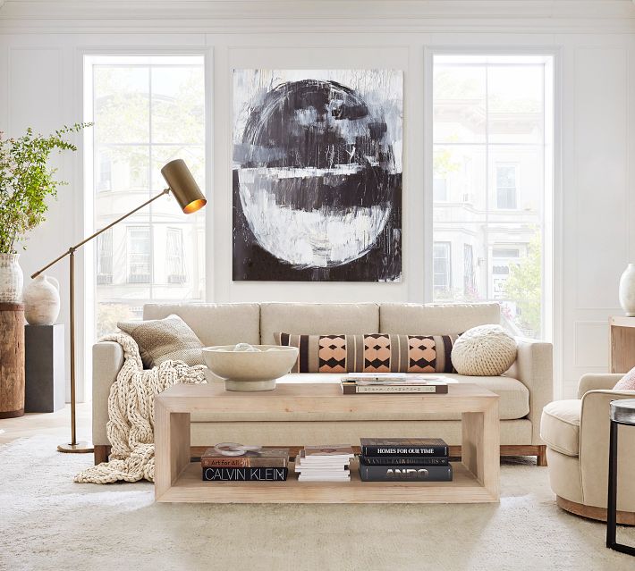 Bright living room with low coffee table, books, and decor on white wall