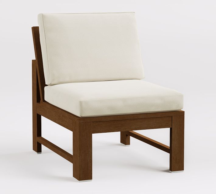 Side view of wooden armchair with cream cushion