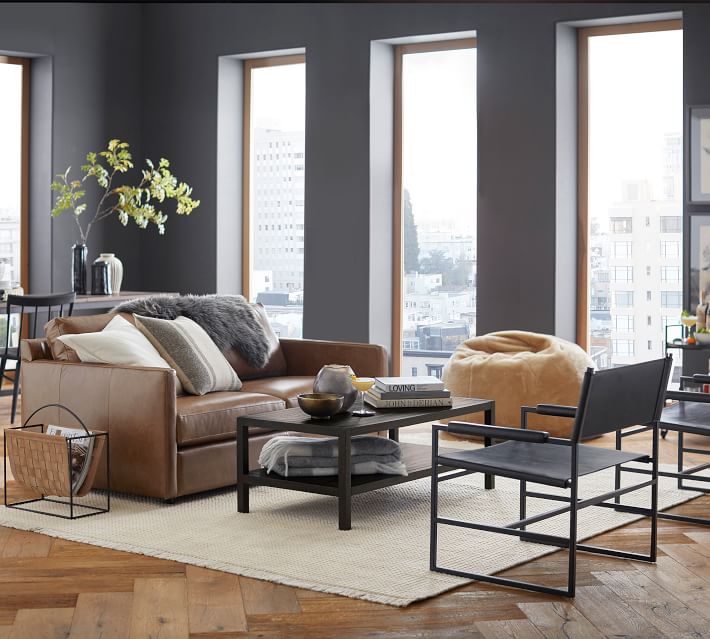 Living room with brown leather sofa and modern chairs
