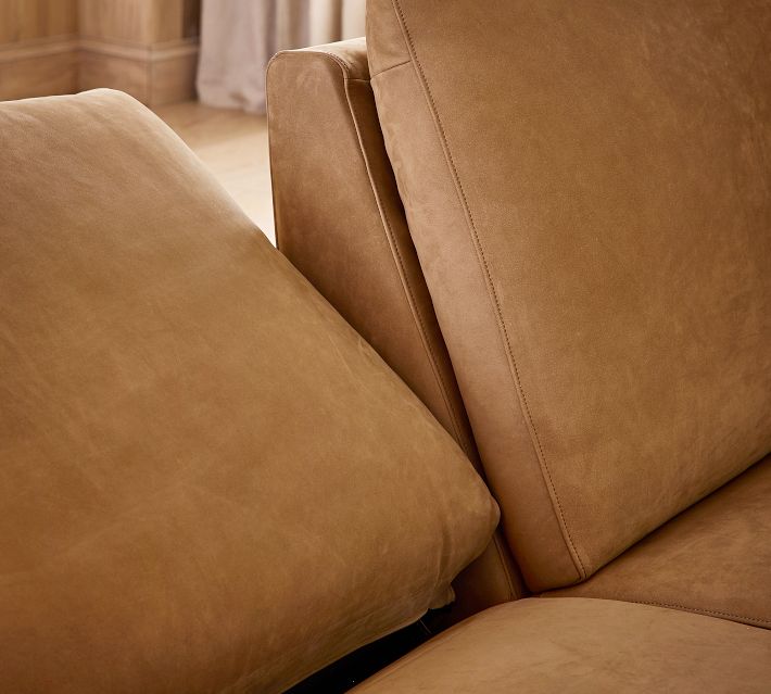 Partial view of tan leather sofa with footwell and armrest visible.