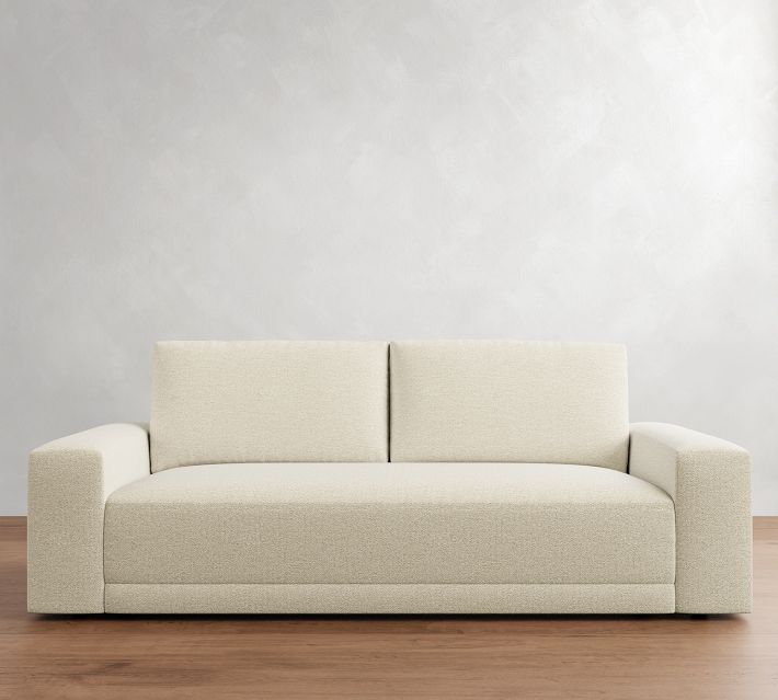 Close-up side view of a beige sofa showing armrest and upholstery
