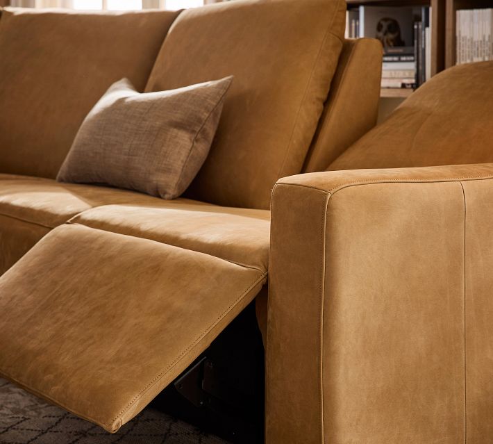 Close-up of leather upholstery on armrest and cushions.