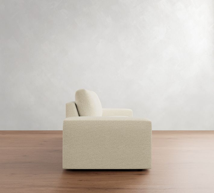 Side view of a beige armchair/sofa with two back cushions