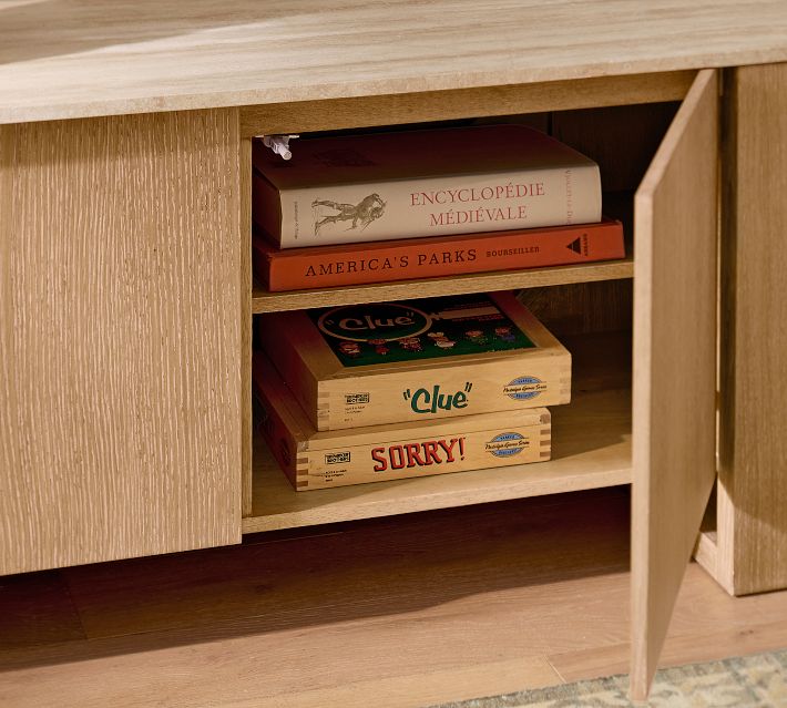 Open shelf in a wooden cabinet showing books and a game box (Clue), with vintage board games stacked