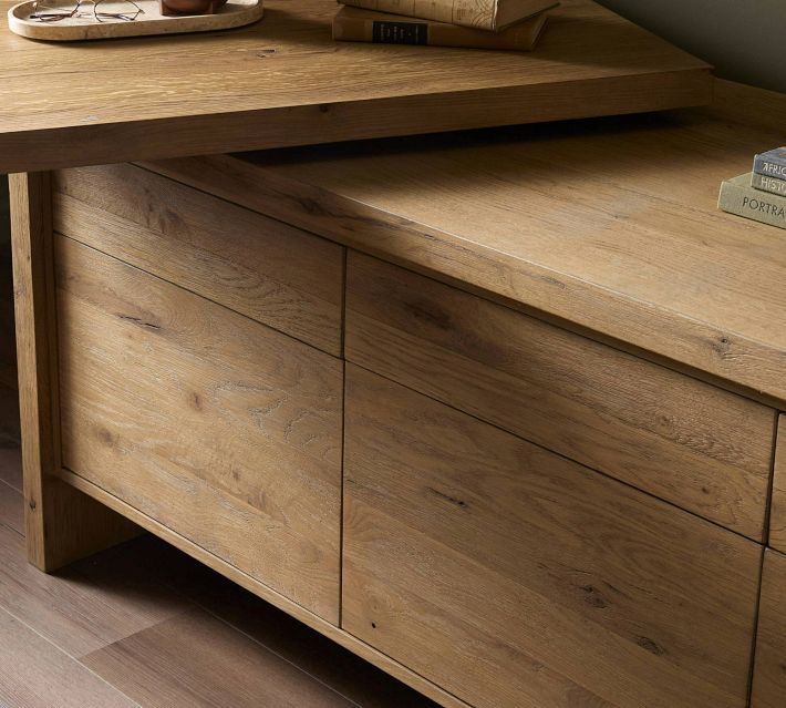 Close-up of the top of a wooden sideboard showing tabletop and drawer fronts in a natural wood finish.