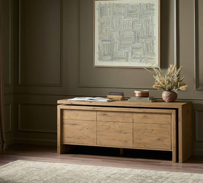 Close-up of a wooden sideboard showing drawers and cabinet doors in a natural wood finish.