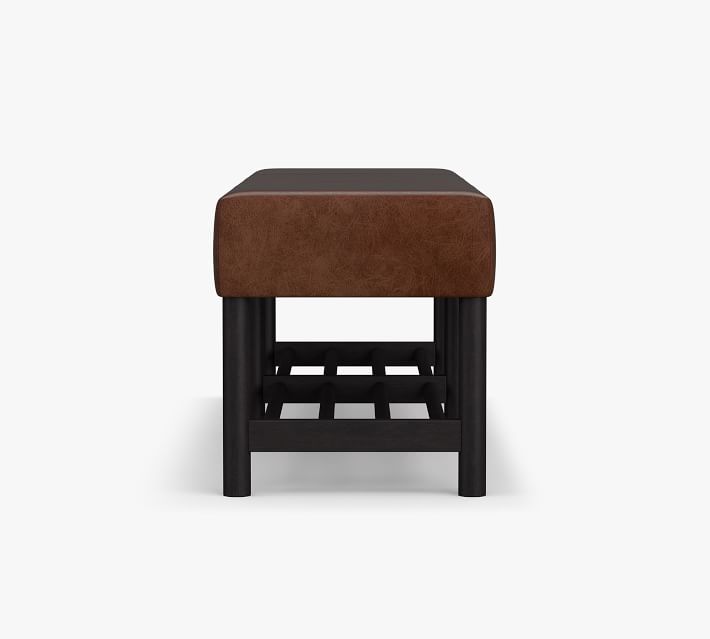 Close-up of lower shelf and wood frame under brown leather bench.