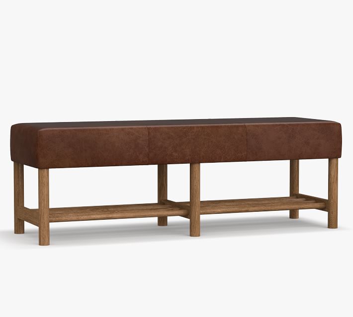 Front-facing view of a brown leather-top bench with a wooden frame and open lower shelf divided into two sections.