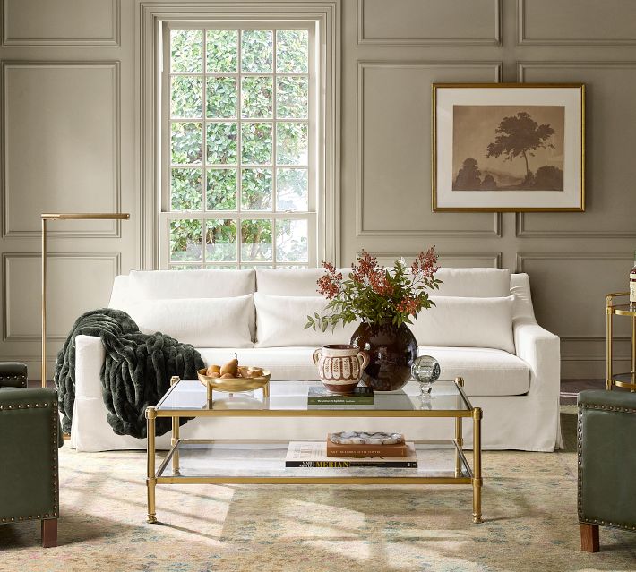 Living room with beige sofa, framed art, and light fixtures.