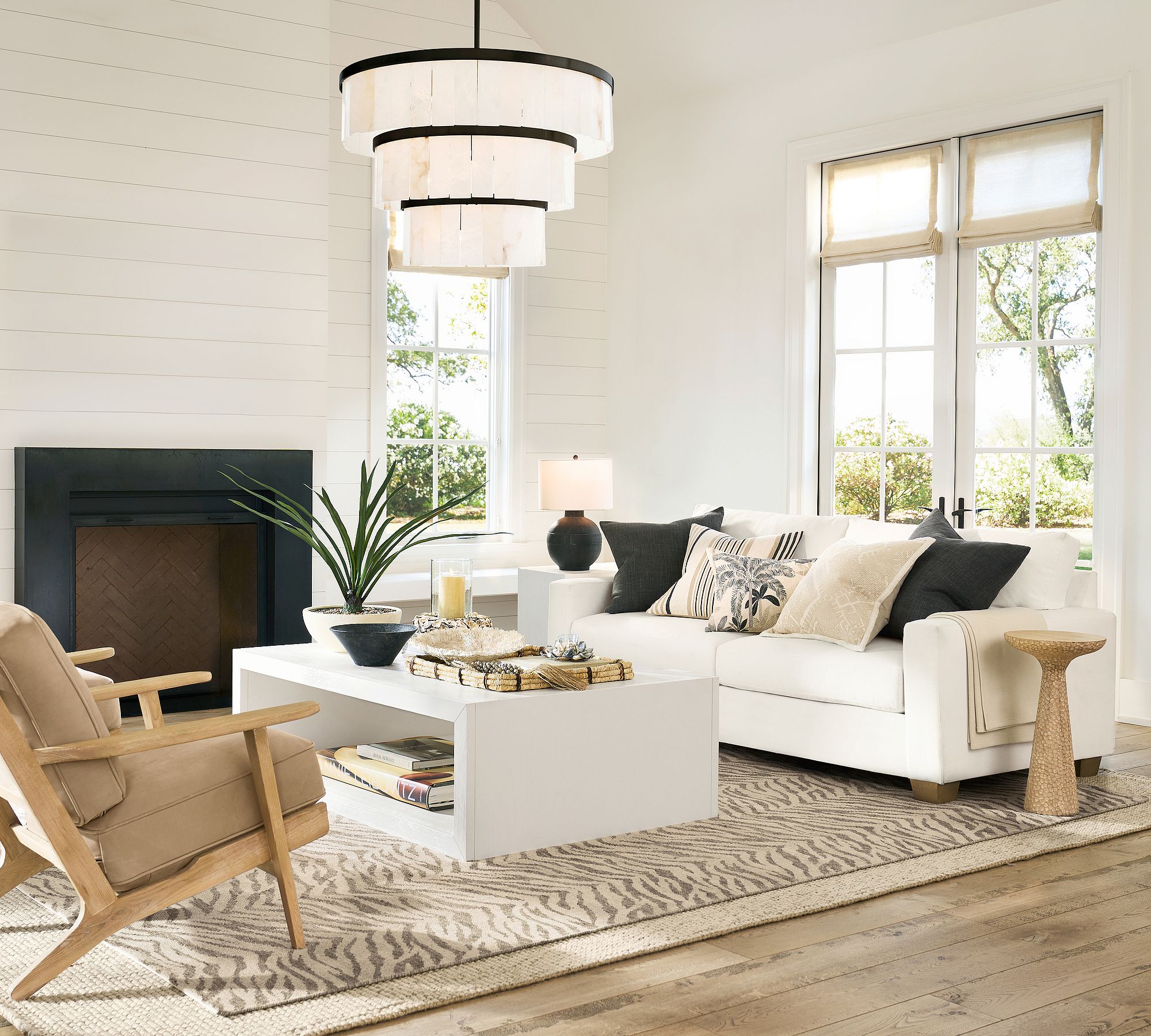 Carved round accent table placed in living room with white sofa and modern decor
