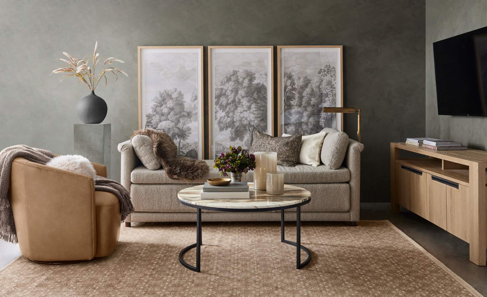 Contemporary living room featuring cream sofa, tan leather swivel chair, and modern oak media console on neutral area rug. Contemporary living room featuring cream sofa, tan leather swivel chair, and modern oak media console on neutral area rug.