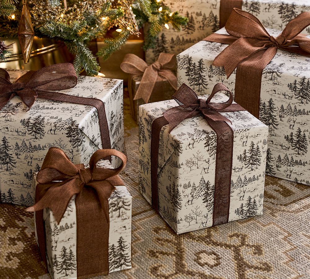 Stylish christmas gift wrapped in fabric on rustic table with