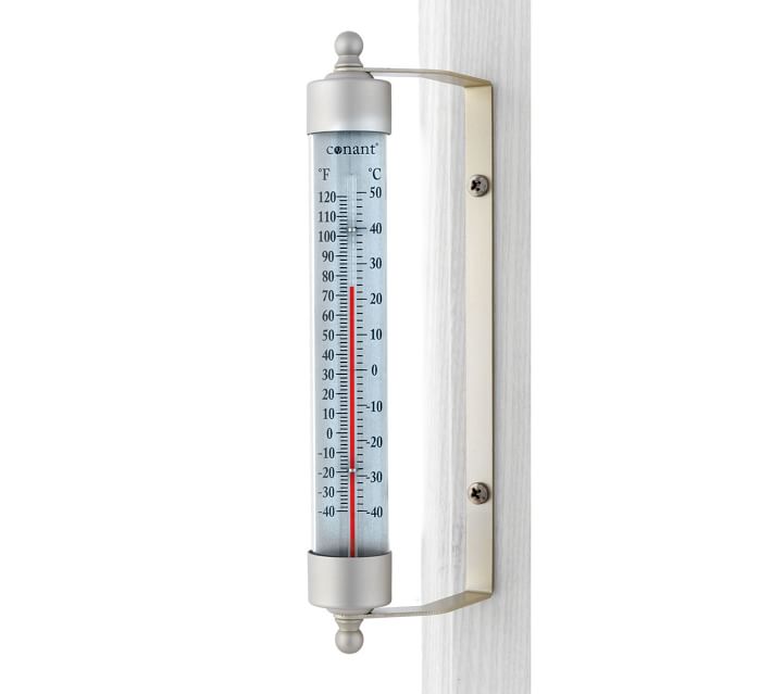 Closeup Of An Outdoor Thermometer Hanging On A Concrete Wall Stock