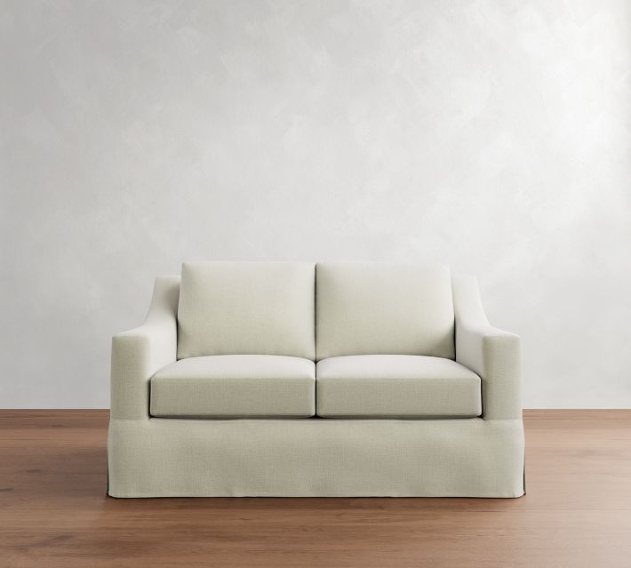 Two-seater beige sofa against a wall