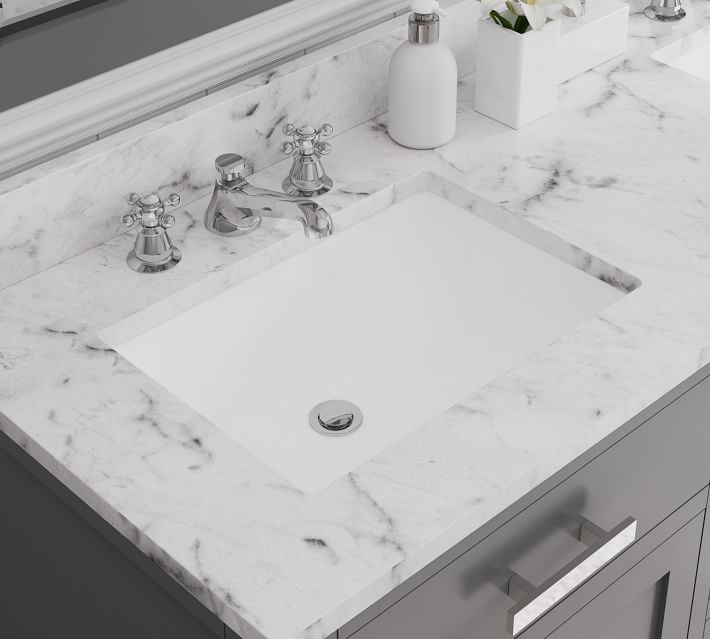 Close-up of a marble sink countertop with faucet and accessories.