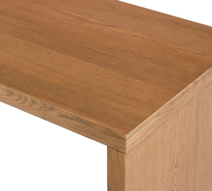 Top of desk showing wood grain and edge with light reflection.