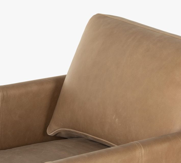Close-up of tan leather cushion on an armchair showing soft texture and stitching
