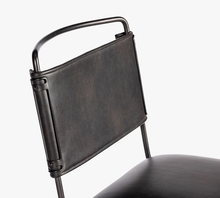 Close-up of the chair backrest and top rail featuring dark brown leather with metal frame