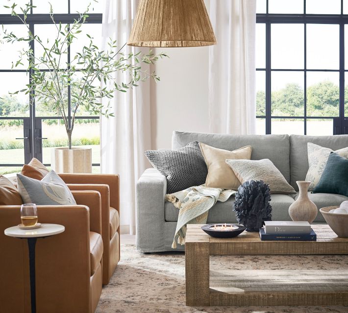 Living room with grey sofas, leather chairs and plants