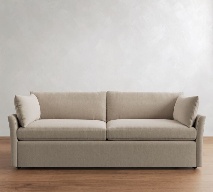 Three-quarter view of beige sofa with cushions from right side.