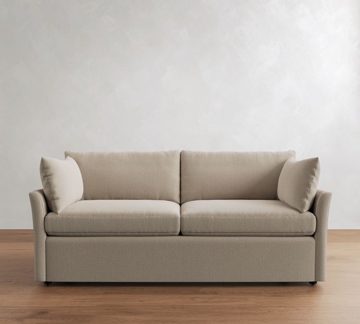 Front view of beige sofa with two seat cushions and two back cushions, base skirtless, on wooden floor.
