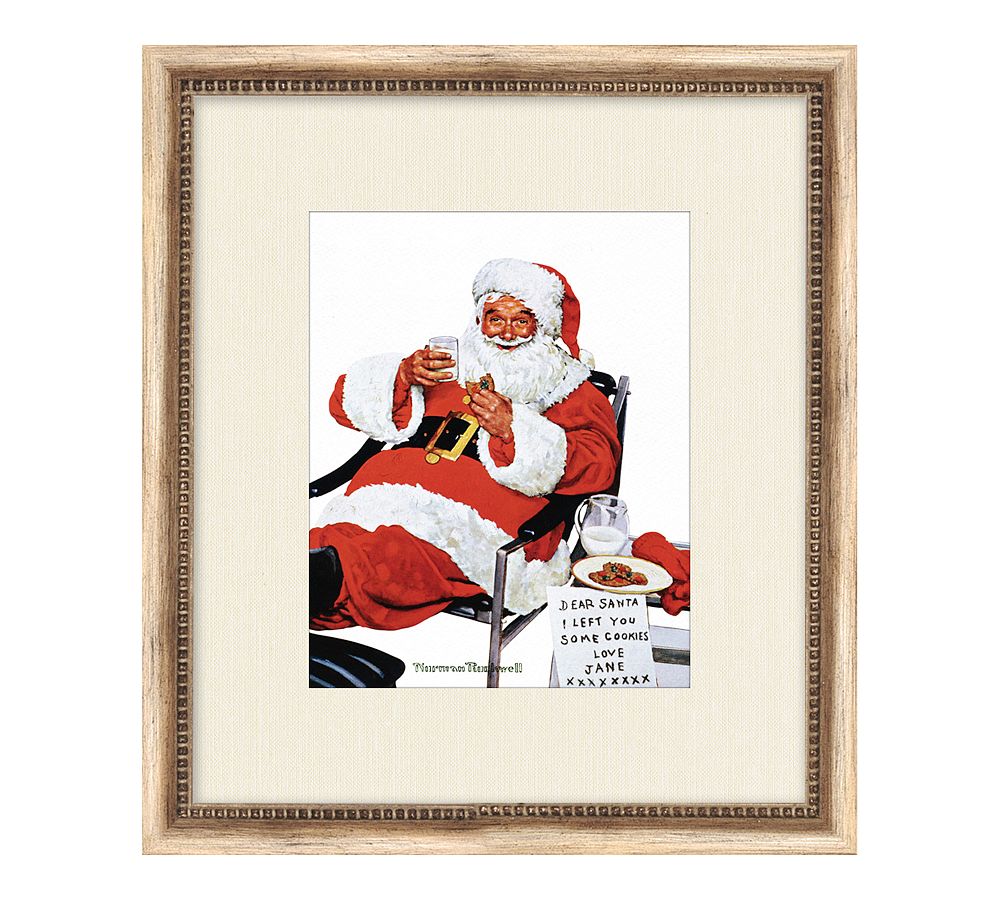 Santa's Milk and Cookies Framed Print by Norman Rockwell