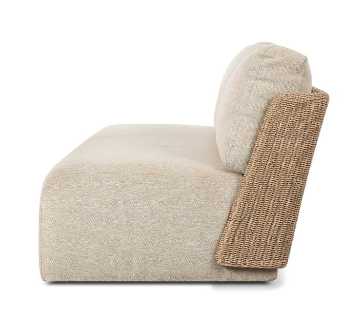 Side view of beige fabric lounge chair with woven rattan armrest