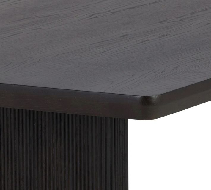 Close-up corner of the dark wood tabletop showing rounded edge and wood grain.