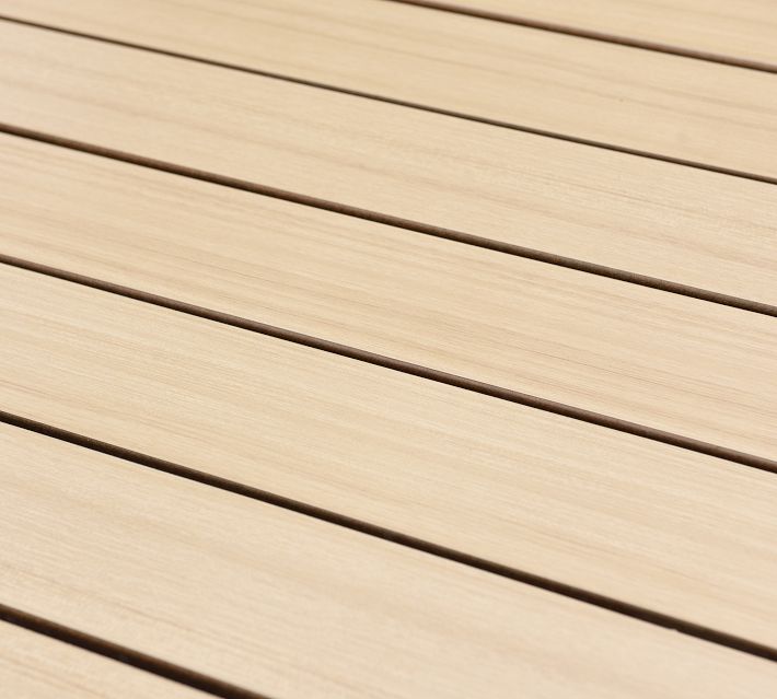 Close-up of light wood slats on a table top with visible grain and gaps between slats.