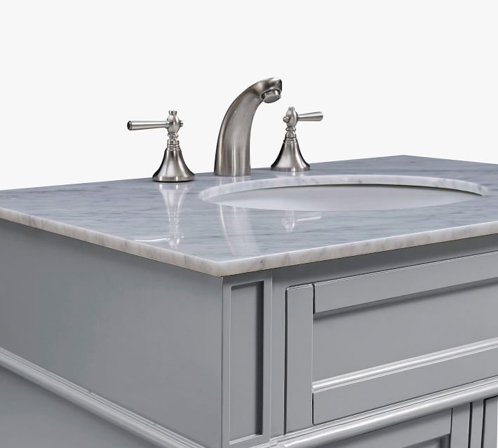 Close-up of faucet and handles on marble vanity