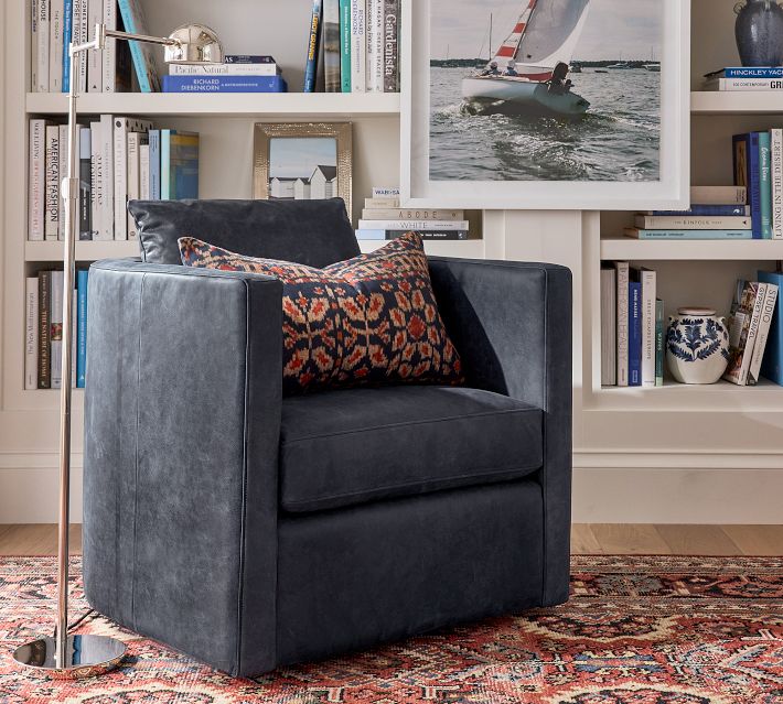 Blue velvet armchair in library-style room with wall shelves
