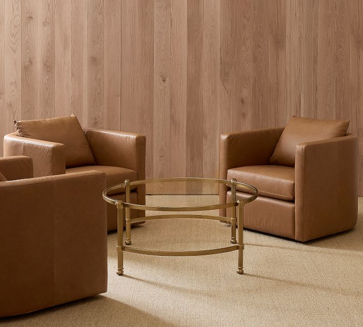 Panel of tan leather chairs with glass coffee table